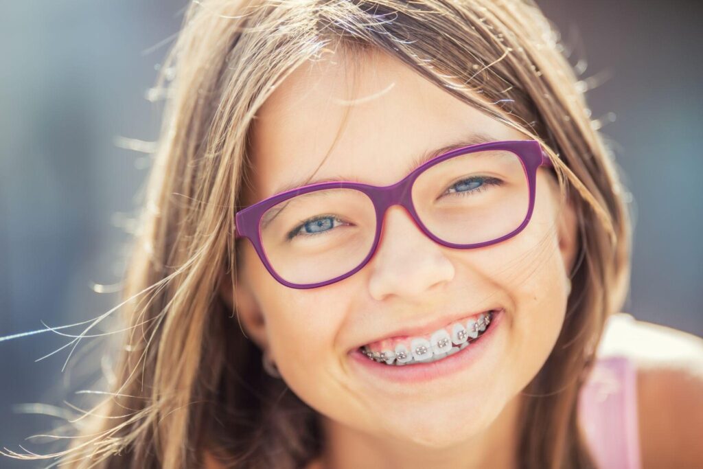 Young girl with braces smiling - orthodontist for kids in Irvine CA Shining Smiles